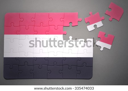 broken puzzle with the national flag of yemen on a gray background