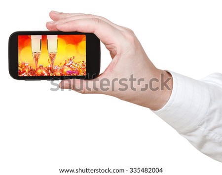 businessman holds smartphone with Christmas still life on screen isolated on white background