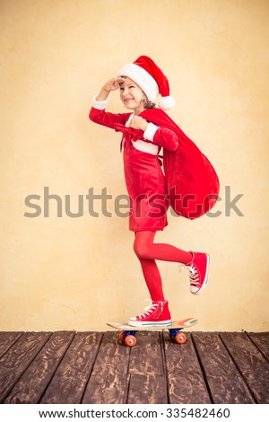 Child riding skateboard. Funny kid with Santa bag. Christmas holiday concept