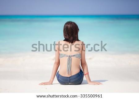 Young Asian woman wearing bikini relaxing on the beach 
