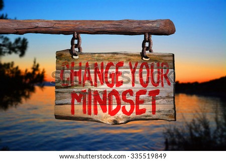 Change your mindset motivational phrase sign on old wood with blurred background