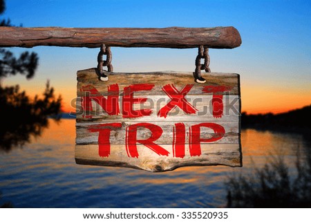 Next trip sign on old wood with a blurred beach on background
