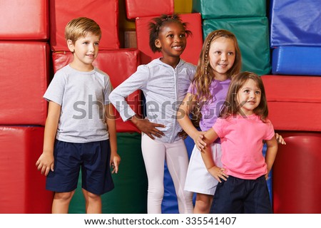 Smiling group of children standing in gym of a elementary school