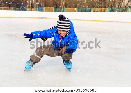 cute little boy learning to skate in winter snow