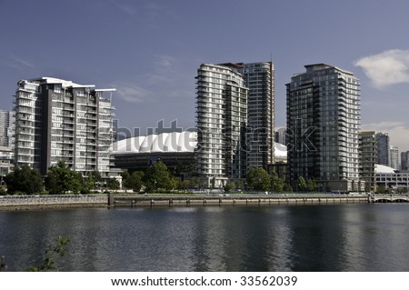 Highrise buildings by the sea side in Vancouver.The white dome is the stadium which will hold the openning ceremonies for the 2010 winter Olympics.Vancouver British Columbia