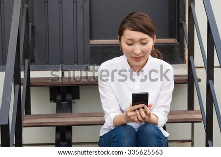 asian woman using smartphone outdoors