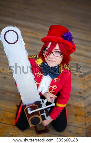 Portrait of the cosplay girl with chainsaw on a wooden background
