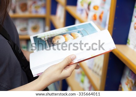 girl reading cooking book in a book store for decision to buy