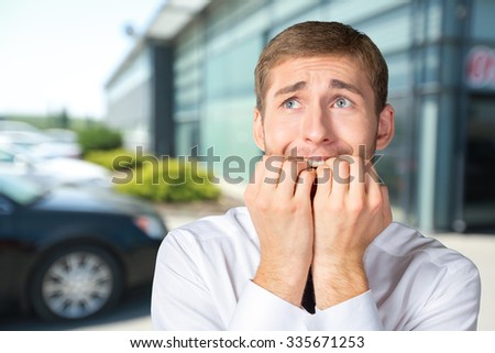 Scared and astonished young businessman