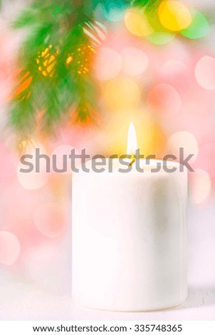 Christmas white candle with lights on the background