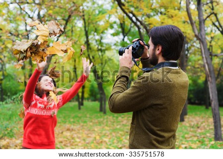 young happy couple taking photos in autumn park