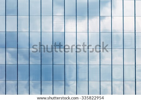 Clouds Reflected in Windows of Modern Office Building. Royalty-Free Stock Photo #335822954
