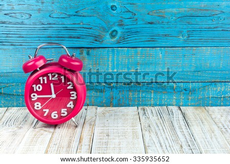 red alarm clock on the wood