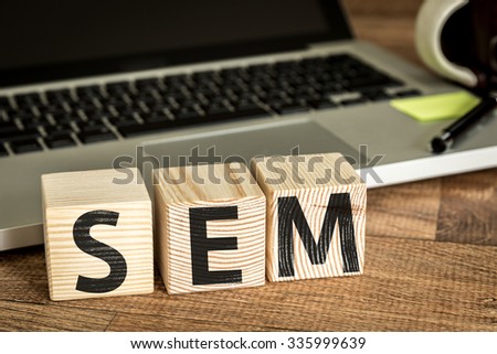 SEM (Search Engine Marketing) written on a wooden cube in a office desk 