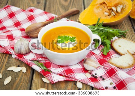 Pumpkin soup puree with spices on a wooden table