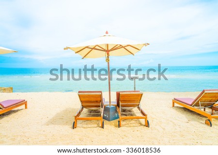 Umbrella and chair on beautiful tropical beach - summer vacation background