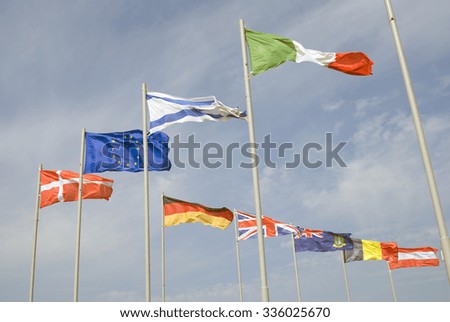 State flags of several countries, European Union flag. Blue sky background.