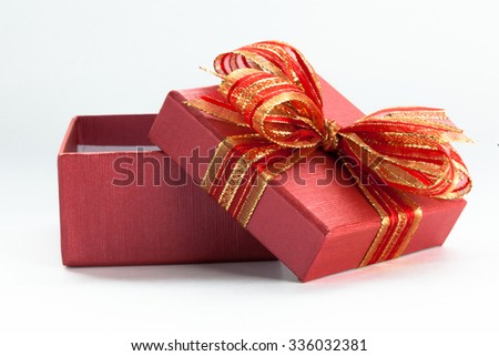 Red festive gift box being opened and left on the side.