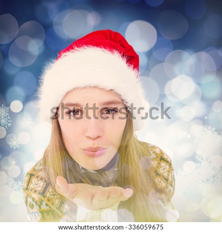Happy hipster blowing kiss against snowflake pattern