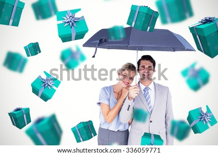 Business people holding a black umbrella against blue and silver presents