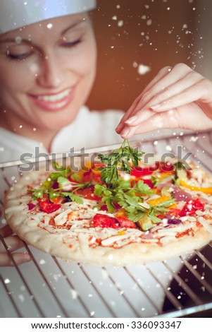 Snow against beaautiful female chef preparing a pizza