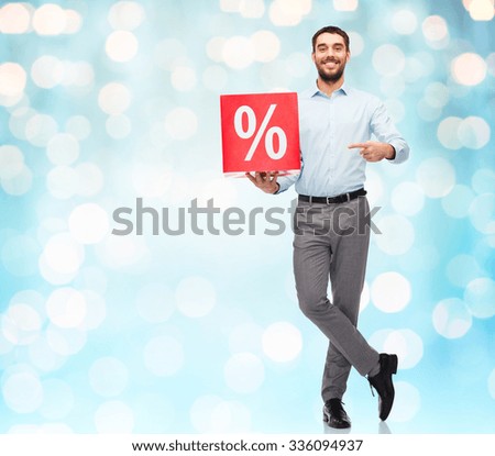 people, sale, shopping, discount and holidays concept - smiling man holding red percentage sign over blue holidays lights background