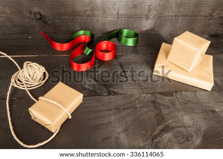 Christmas composition on wooden background and elements such as gifts, pine needles and ties, green and red Christmas