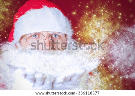 Christmas winter with Santa Claus blowing magical glitter, stardust. Red background. New Year.