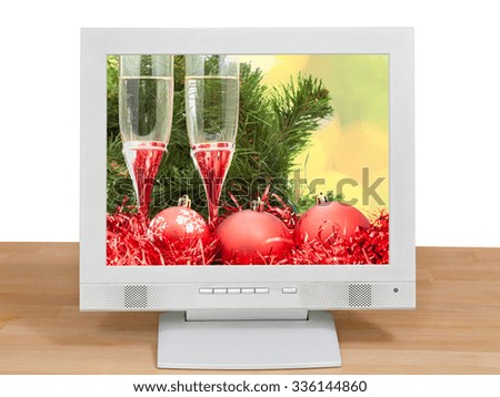 Christmas still life with red balls and glasses on screen of gray monitor isolated on white background