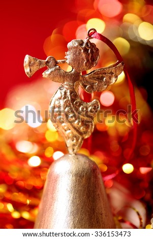 Christmas golden Angel toy playing trumpet  close-up on blurred holiday background