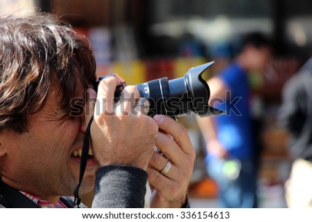 A man taking photographs of a New York City chinatown market.