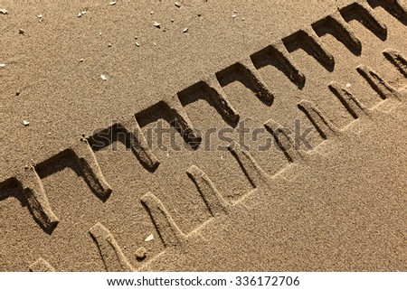 tire tracks prints in sand on a beach 