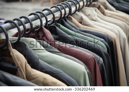 Selective focus some used leather clothes hanging on a rack in a  market, retro picture style