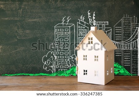 photo of house and background of blackboard and city drawings. real estate and family house concept 