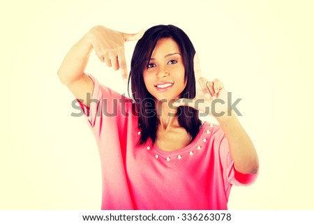 Smiling woman  is showing frame by hands. Happy girl with face in frame of palms.