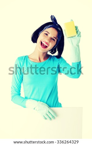Smiling happy cleaning woman showing blank sign board.