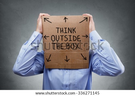 Businessman with cardboard box on his head saying think outside the box concept for brainstorming, creativity, innovation, strategy or individuality
