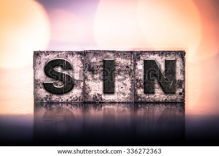 The word "SIN" written in vintage ink stained letterpress type. Royalty-Free Stock Photo #336272363