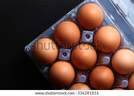 The chicken egg put on the plastic containing  tray represent the food packaging and food concept related idea.