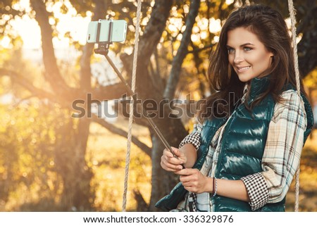 Beautiful woman taking selfie in autumn park