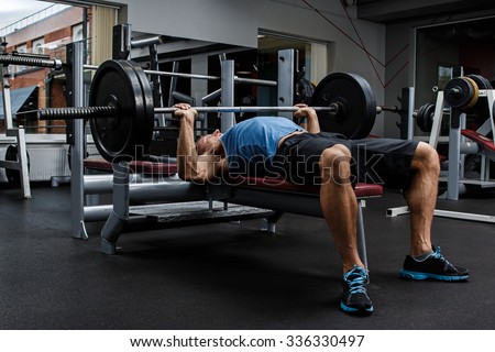 Man during bench press exercise in gym Royalty-Free Stock Photo #336330497