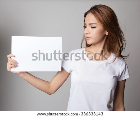 Beautiful asian woman holding blank card or paper, presenting and showing.