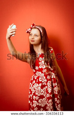 Happy smiling little girl child making self portrait on smartphone 