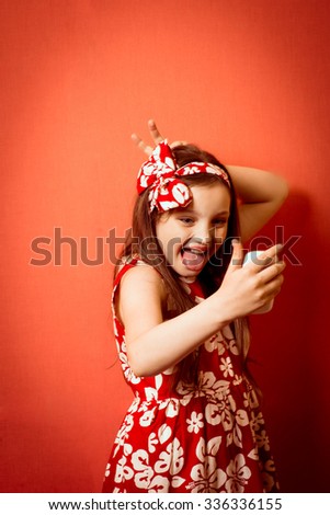 Fashionable little girl making funny Phone SELF