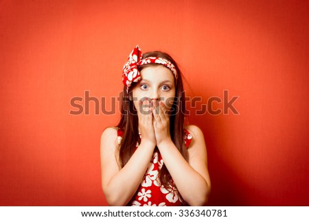 Little baby girl covers her mouth with her hands