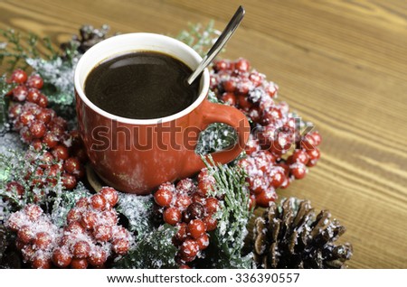 Christmas wreath and cup of coffee on a wooden background.
