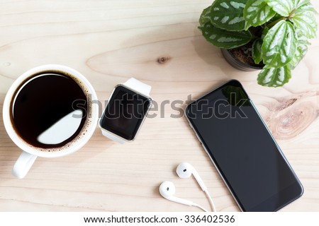 phone and hand watch on wood desk top view Royalty-Free Stock Photo #336402536