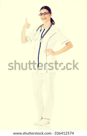 Young beautiful doctor, nurse with stethoscope showing ok.