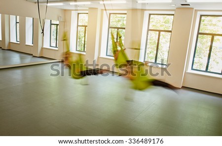 fitness club with three women in hammocks. indoor fitness club. motion