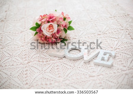 Bridal bouquet and letters making up the word "Love" in a bright room on the bed. wedding decorations